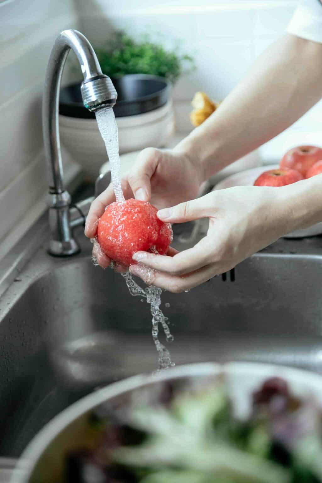 Fresh fruit being washed as part of food hygiene and safe food preparation in a nursery