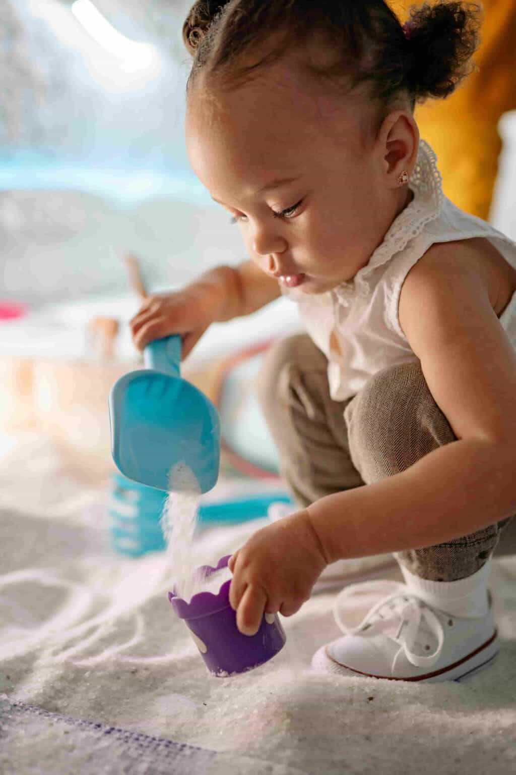 Child focused on sensory play activity in early years nursery setting