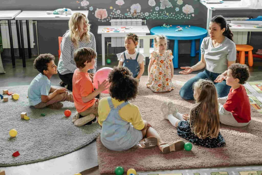 Children taking part in a nursery group activity with early years practitioners