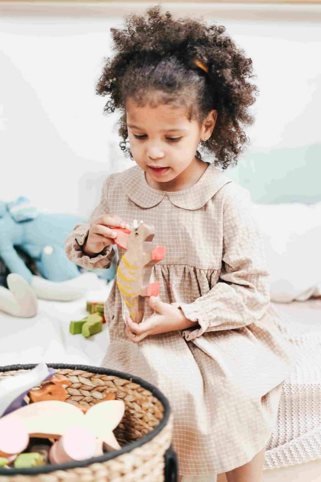 Child using imaginative play with wooden toys to develop creativity and problem-solving skills