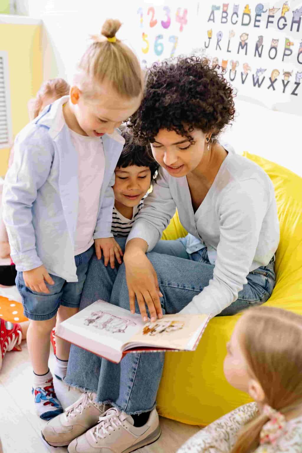 Nursery practitioner reading a story with children to support speech and language development