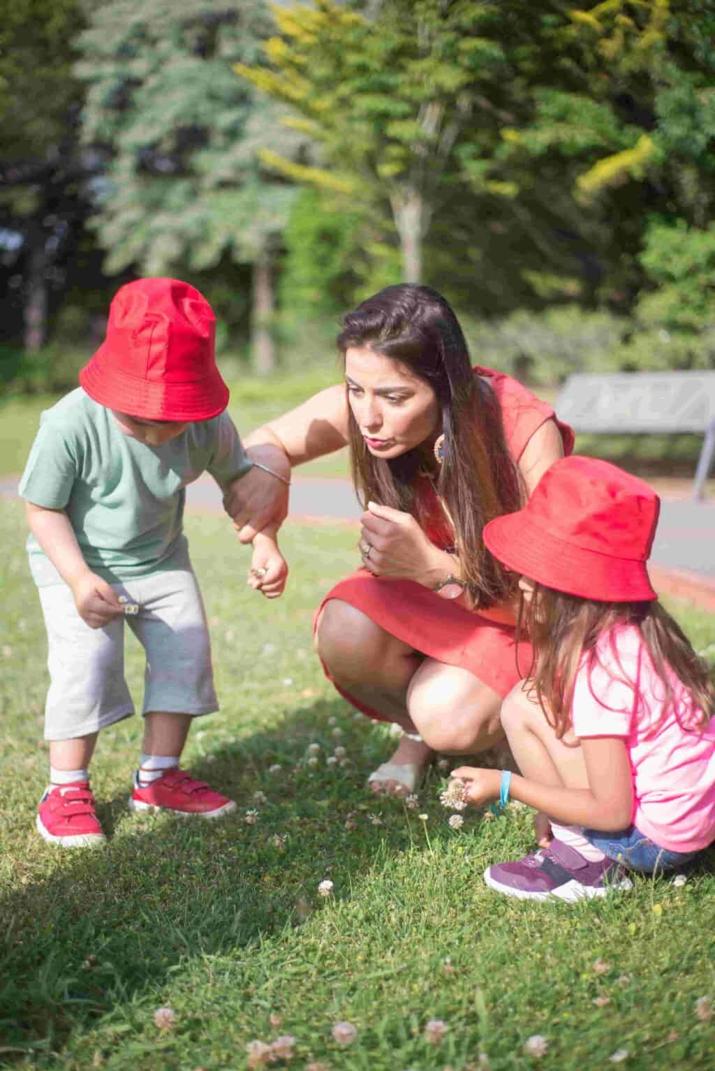 Adult and young children exploring flowers outdoors - screen free activities