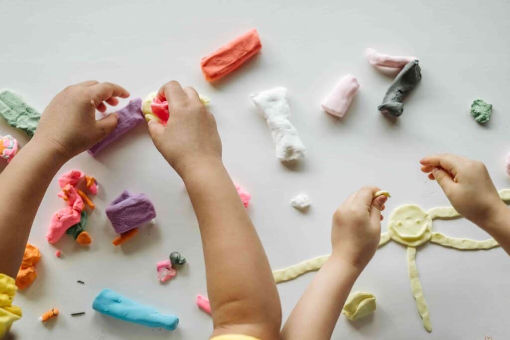Children developing fine motor skills through creative playdough activities